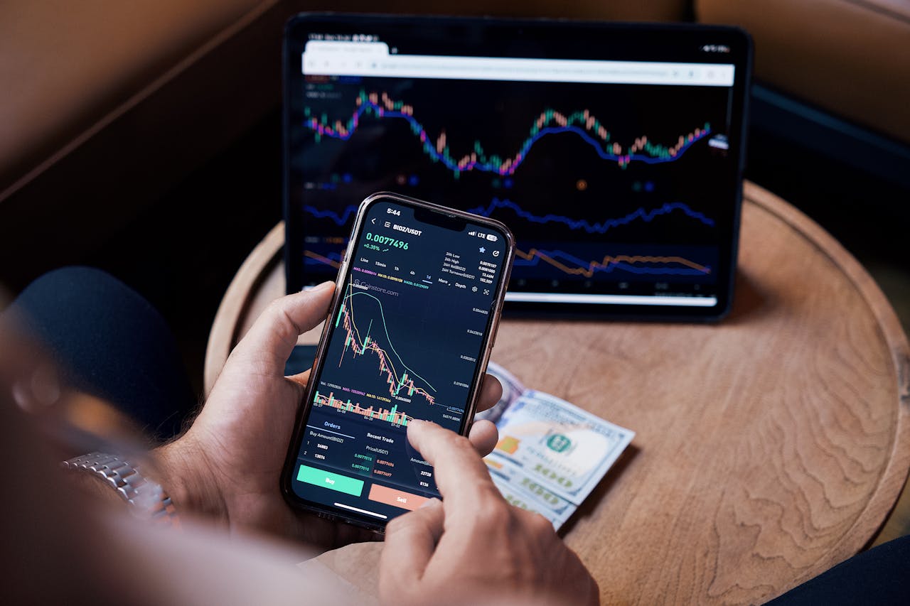 hero-gallery-04 Close-up of a person trading stocks using a smartphone and a tablet.